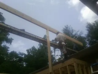Carpenter setting a ridge beam over a new addition frame — Ice Dam Removal by Roofing Brothers in Sharon Grove