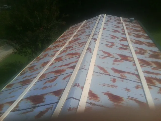 Rusted metal roof panels with new wood purlins before replacement — Storm Damage Roof Repair in Sharon Grove by Roofing Brothers