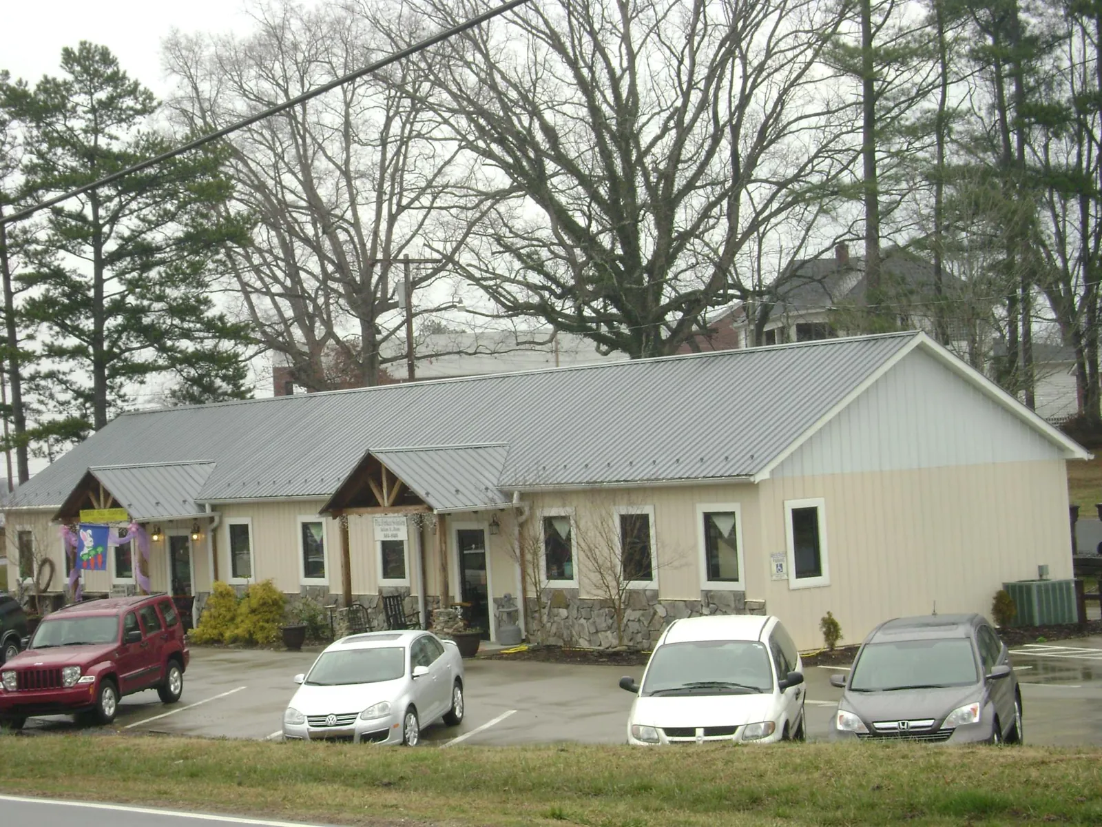 Gray metal roof with timber entry brackets on a small commercial building in Sharon Grove